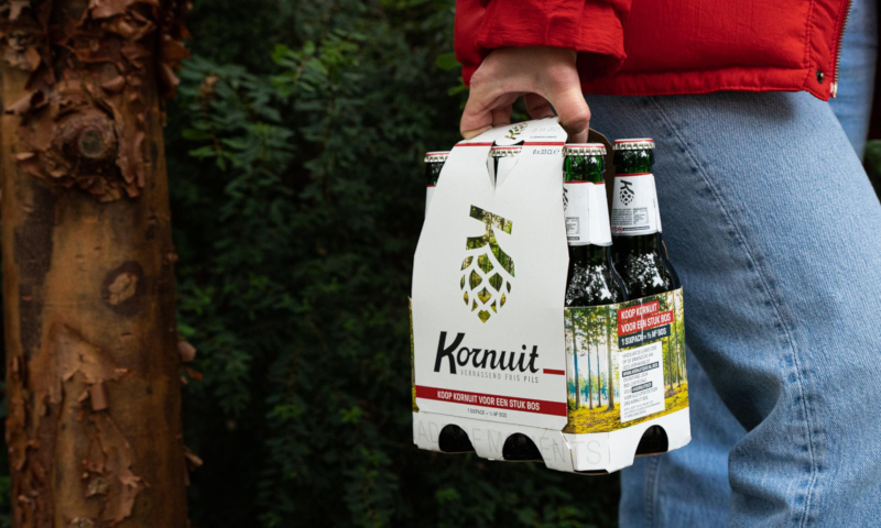 Man loopt met sixpack Kornuit in het bos